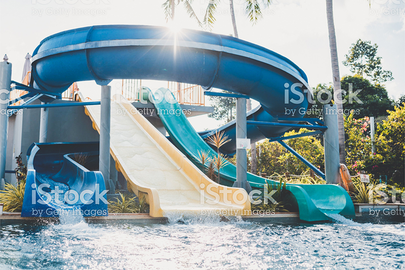 Shot of empty parallel slides at water park. Sunlight in the back.